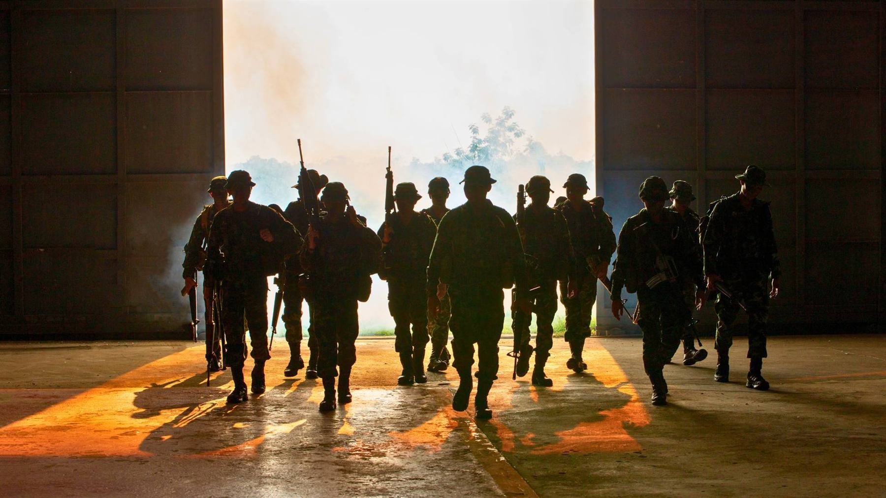 Military personnel deploying from a hangar at first light